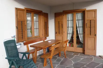 a dining room with a wooden table and two chairs at Appartamento Zorzi in Ziano di Fiemme