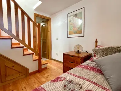 a bedroom with a bed and a wooden floor at El Fogher in San Vito di Cadore