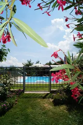 a gate leading to a pool with pink flowers at Haus Ebner Eppan an der Weinstraße St Pauls in Appiano sulla Strada del Vino