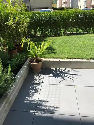 a sidewalk with plants on it next to a yard at Schöne Neubauwohnung mit Garten in Merano