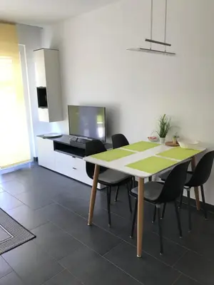 a dining room with a table and chairs at Schöne Neubauwohnung mit Garten in Merano