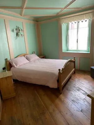 a bedroom with a large bed with pink pillows at Casa Mia Fiemme in Carano