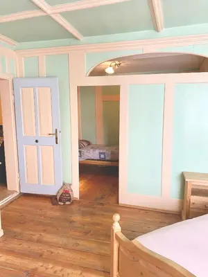 a bedroom with a bed and a room with a door at Casa Mia Fiemme in Carano