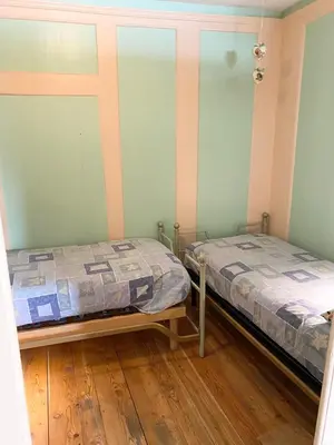 two twin beds in a room with wooden floors at Casa Mia Fiemme in Carano