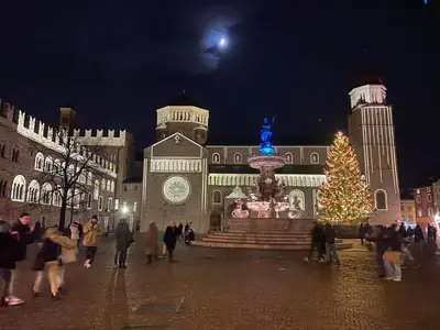 a group of people walking in front of a building with a christmas tree at Casa Mia Fiemme in Carano