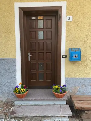 a wooden door with two pots of flowers in front of it at Casa Mia Fiemme in Carano