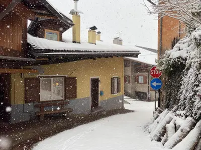 a house with a stop sign in the snow at Casa Mia Fiemme in Carano