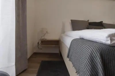a bedroom with a bed with a nightstand next to it at Apartment Mia in Merano