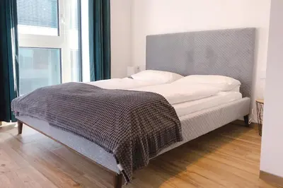 a bed with a blanket on it in a bedroom at Laurentia Penthouse Apartment in Merano