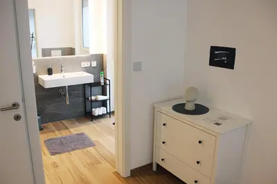a small bathroom with a sink and a dresser at Laurentia Penthouse Apartment in Merano