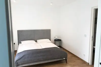a bedroom with a large bed with two pillows at Laurentia Penthouse Apartment in Merano