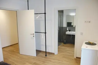 a bathroom with a white door and a sink at Laurentia Penthouse Apartment in Merano