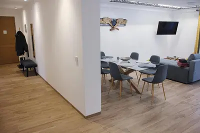 a dining room with a table and chairs and a couch at Laurentia Penthouse Apartment in Merano