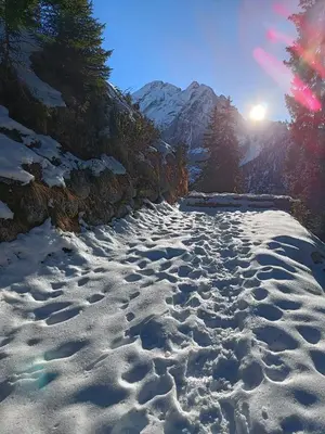 a snow covered mountain with the sun in the background at Orchidea Suite & SPA Apartments in Canazei