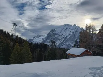 a snow covered mountain with a ski lift and a cabin at Orchidea Suite & SPA Apartments in Canazei
