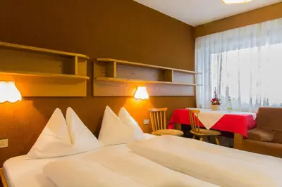 a hotel room with a bed and a table with a table at GARNI AQUILA in Corvara in Badia