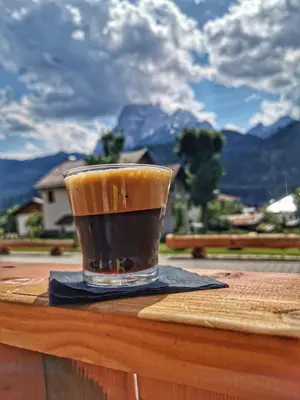 a cup of coffee sitting on top of a table at Hotel Oasi in San Vito di Cadore