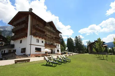 a group of chairs in front of a building at Hotel Oasi in San Vito di Cadore