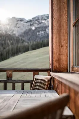 a table and chairs on a porch with a view of a mountain at Agriturismo Maso Runch in Badia
