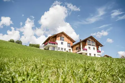 a house on top of a green hill at Agriturismo Maso Runch in Badia