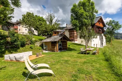 a bench sitting in the grass in front of a house at Agriturismo Maso Runch in Badia