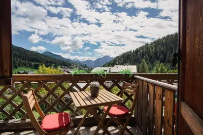 a table and chairs on a balcony with a view at Hotel Sporting in Val di Zoldo