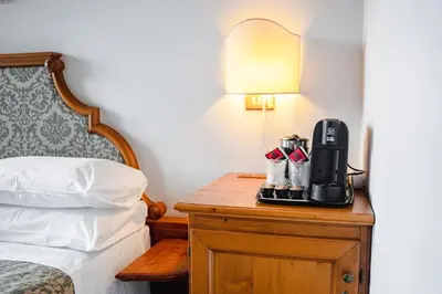 a hotel room with a coffee maker on a table next to a bed at Hotel Sporting in Val di Zoldo