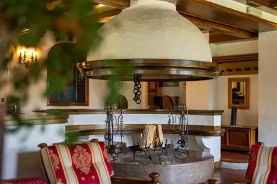 a kitchen with a stove and some chairs at Hotel Sporting in Val di Zoldo