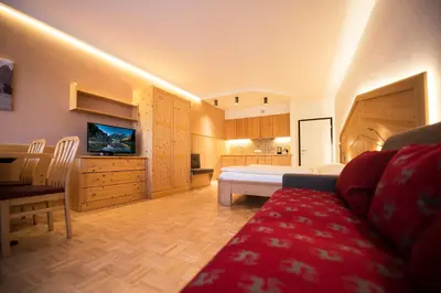 a large bedroom with a bed and a kitchen at Apartment Lilli mit Garagenstellplatz in Bressanone