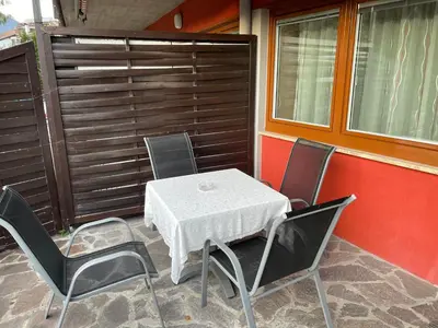 a white table and chairs on a patio at Apartment Lilli mit Garagenstellplatz in Bressanone