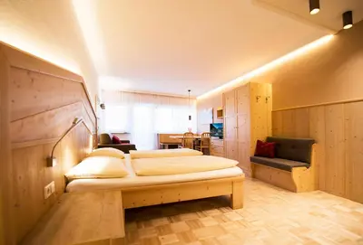 a bedroom with two beds and a couch in it at Apartment Lilli mit Garagenstellplatz in Bressanone