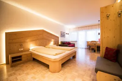 a bedroom with two beds and a living room at Apartment Lilli mit Garagenstellplatz in Bressanone