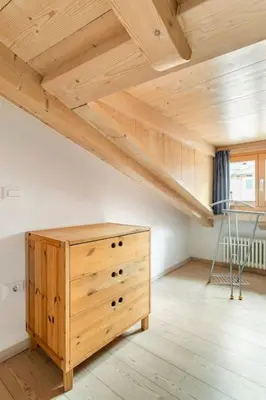 a room with a wooden dresser in a attic at Appartamento rustico con stube e balcone in Predazzo