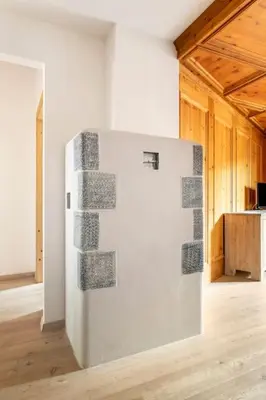 a white refrigerator in a room with a wooden floor at Appartamento rustico con stube e balcone in Predazzo