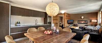 a kitchen and living room with a wooden table at Chalet Mi Amur in La Villa