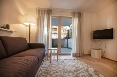 a living room with a couch and a large window at Apartment Lulu in Selva di Val Gardena