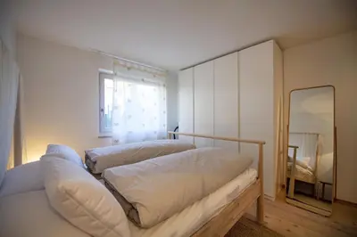 a bedroom with two beds and a mirror at Apartment Lulu in Selva di Val Gardena