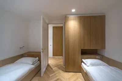 a bedroom with two beds and a door open at Apartment Genziana in Ortisei