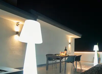 a dining room with a table and chairs at night at Penthouse I CIPRESSI in Postal