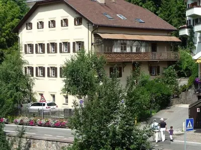 a large white building with a brown roof at ATI Appartamento stile Chalet dell 800 nel cuore di Ortisei in Ortisei