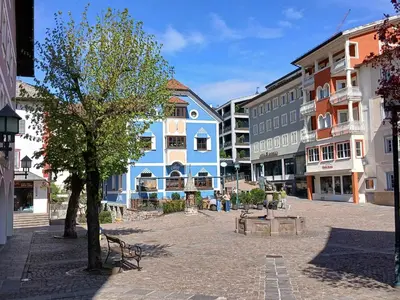 a street in a town with a blue building at ATI Appartamento stile Chalet dell 800 nel cuore di Ortisei in Ortisei