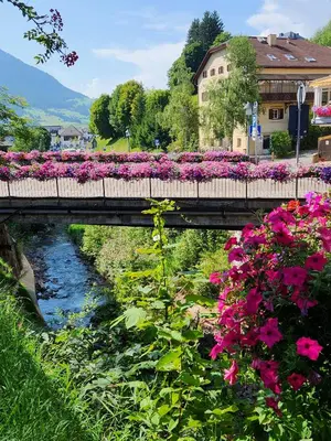 a bridge with flowers on it over a river at ATI Appartamento stile Chalet dell 800 nel cuore di Ortisei in Ortisei