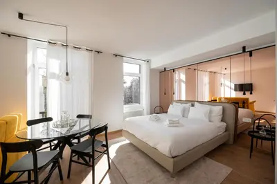 a bedroom with a bed and a table and chairs at Guesthouse diWINE in Merano