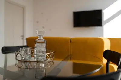 a glass table with a bottle and glasses on it at Guesthouse diWINE in Merano
