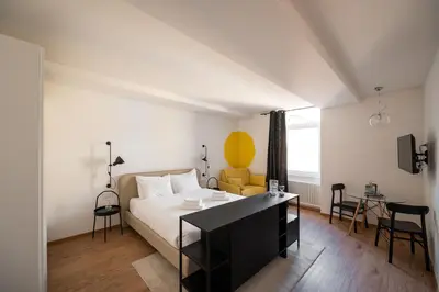 a bedroom with a bed and a table and chairs at Guesthouse diWINE in Merano