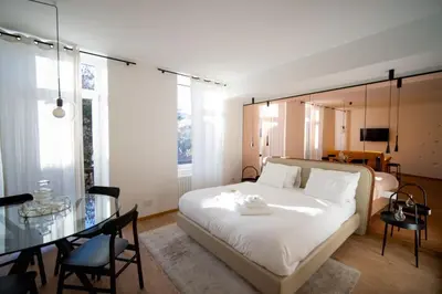 a bedroom with a bed and a glass table at Guesthouse diWINE in Merano