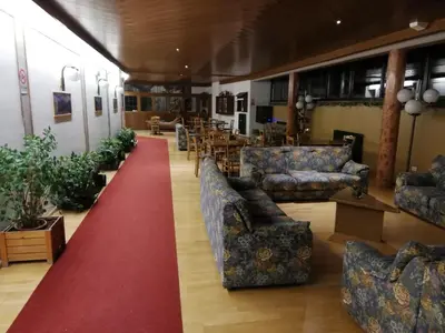 a living room with couches and a red carpet at Tana delle Marmotte in Falcade