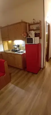 a small kitchen with a red refrigerator in a room at Tana delle Marmotte in Falcade