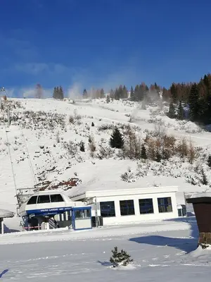 a building in the snow with a snow covered slope at Tana delle Marmotte in Falcade
