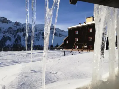 an ice sculpture of a playground with mountains in the background at Tana delle Marmotte in Falcade
